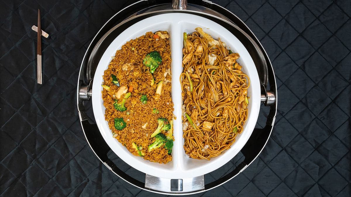 Fried rice and lo mein side by side in a catering chafer